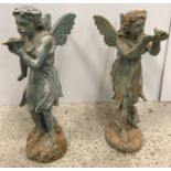 A cast iron figure of a fairy with shell in her hand and another with bird in her hand,