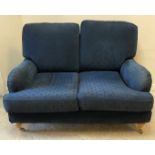 A pair of modern blue upholstered two seat sofas in the Howard style with curved side rails raised