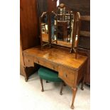 An early to mid 20th Century walnut triple wardrobe in the Georgian style,