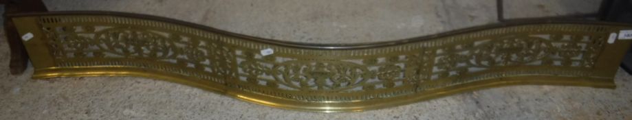 An early 19th Century pierced brass serpentine fire fender 125 cm wide x 17 cm high