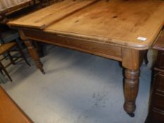 A Victorian pine dining table, the rounded rectangular top with extra leaf,
