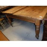 A Victorian pine dining table, the rounded rectangular top with extra leaf,