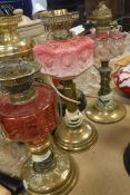 A Victorian brass oil lamp with cranberry glass reservoir 37.