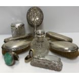 A collection of silver mounted dressing table accountrements to include a grenade scent bottle,