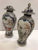 A pair of 19th Century Chinese blue and white and polychrome decorated baluster shaped vases and