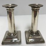 A pair of late 18th Century silver candlesticks of plain column form raised on square tapered base