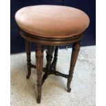 A late Victorian rosewood framed adjustable piano stool, the circular upholstered seat on turned,