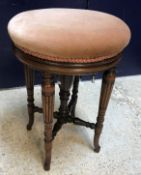 A late Victorian rosewood framed adjustable piano stool, the circular upholstered seat on turned,