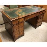 A mahogany kneehole desk, the tooled and gilded leather insert top over three frieze drawers,