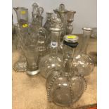 A collection of thirteen various cut glass or blown glass decanters and ewers,
