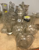 A collection of thirteen various cut glass or blown glass decanters and ewers,