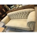 A circa 1900 upholstered scroll arm button back sofa on square tapered legs to brass caps and