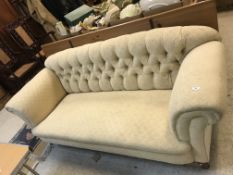 A circa 1900 upholstered scroll arm button back sofa on square tapered legs to brass caps and