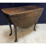 A late George III oak oval drop-leaf dining table on cabriole legs to hoof feet, 114 cm long x 96.