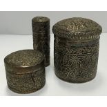 A Burmese white metal cylindrical lidded pot decorated with a band of fish above a forest scene