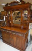 A Victorian mahogany mirror back sideboard with two drawers over two cupboard doors on a plinth