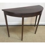 Two mahogany demi-lune side tables, one with cross-banded top on square tapered legs,