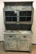 An Australian painted pine kitchen cabinet with shelf over two glazed cupboard doors enclosing