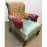An early 20th Century wing back scroll arm chair on barley-twist supports to block feet,