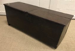 An 18th Century oak hutch or six plank coffer with notch carved ends to the front panel,