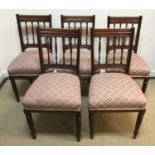 A set of five late Victorian spindle back dining chairs with upholstered seats on turned front legs