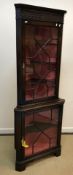 A modern reproduction mahogany corner cabinet with blind fretwork carved frieze over two astragal