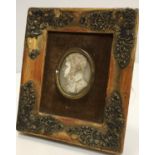 A 19th Century carved ivory portrait medallion on a gentleman in a high collared coat,