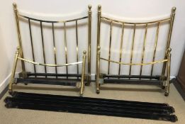 A pair of tubular brass framed single bedsteads with upholstered bases in the Victorian style,