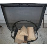 A modern black painted wrought iron spark guard and a wrought iron log basket,