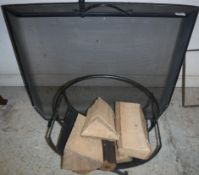 A modern black painted wrought iron spark guard and a wrought iron log basket,