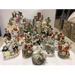 A collection of sixteen various Staffordshire spill vases to include a pair of figures by road sign