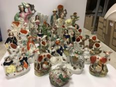 A collection of sixteen various Staffordshire spill vases to include a pair of figures by road sign