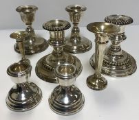 Three pairs of silver squat candlesticks, all on circular bases (various makers),