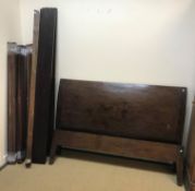A Lombok teak king size sleigh bed with curved ends on square tapered legs,