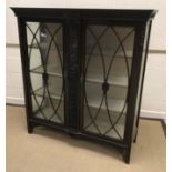 An Edwardian mahogany and carved display cabinet with scrolling foliate decoration,