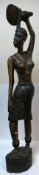 A carved king ebony full standing figure of a woman with paddle above her head,