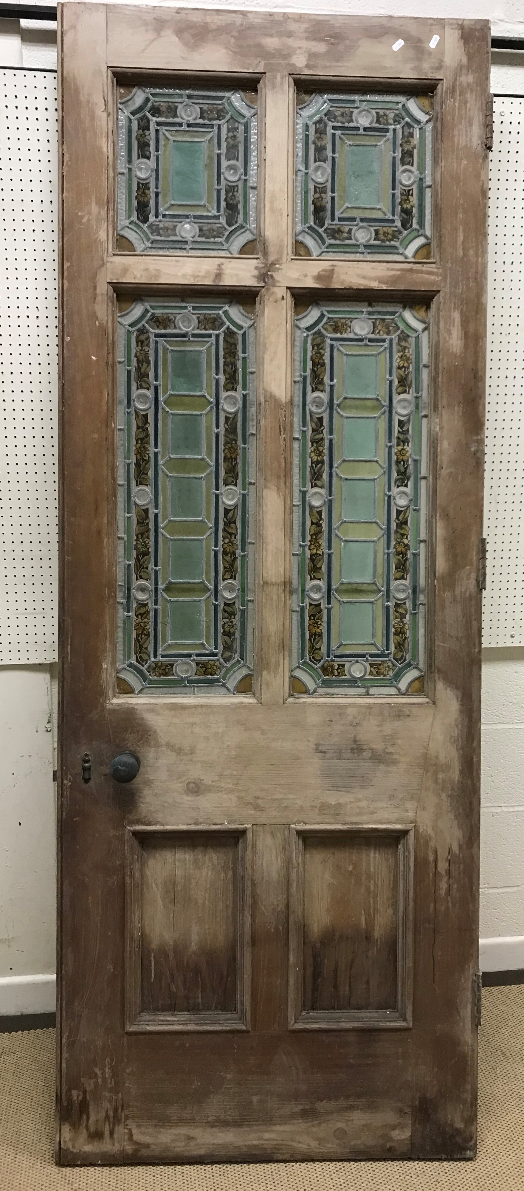 A late Victorian pine framed exterior door with four foliate and floral decorated leaded glazed