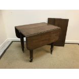 A Victorian mahogany drop-leaf Pembroke style extending dining table with two centre leaves,