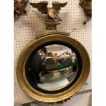 A 19th Century giltwood and gesso framed wall mirror with convex plate and spreadeagle surmount, 55.