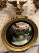 A 19th Century giltwood and gesso framed wall mirror with convex plate and spreadeagle surmount, 55.