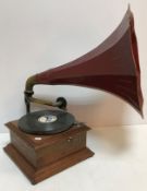 A late Victorian oak cased gramophone by Dulcephone with red and gilt painted nonagon shaped horn,