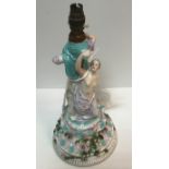 A Joseph Gaspard Robert porcelain table centre as two figures on a rose decorated socle base