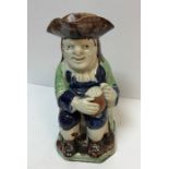 A 19th Century pearl ware glazed pottery Toby jug as "Toby Philpott seated with jug of ale on his
