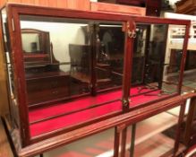 A circa 1900 mahogany framed and glazed hanging shop display cabinet,