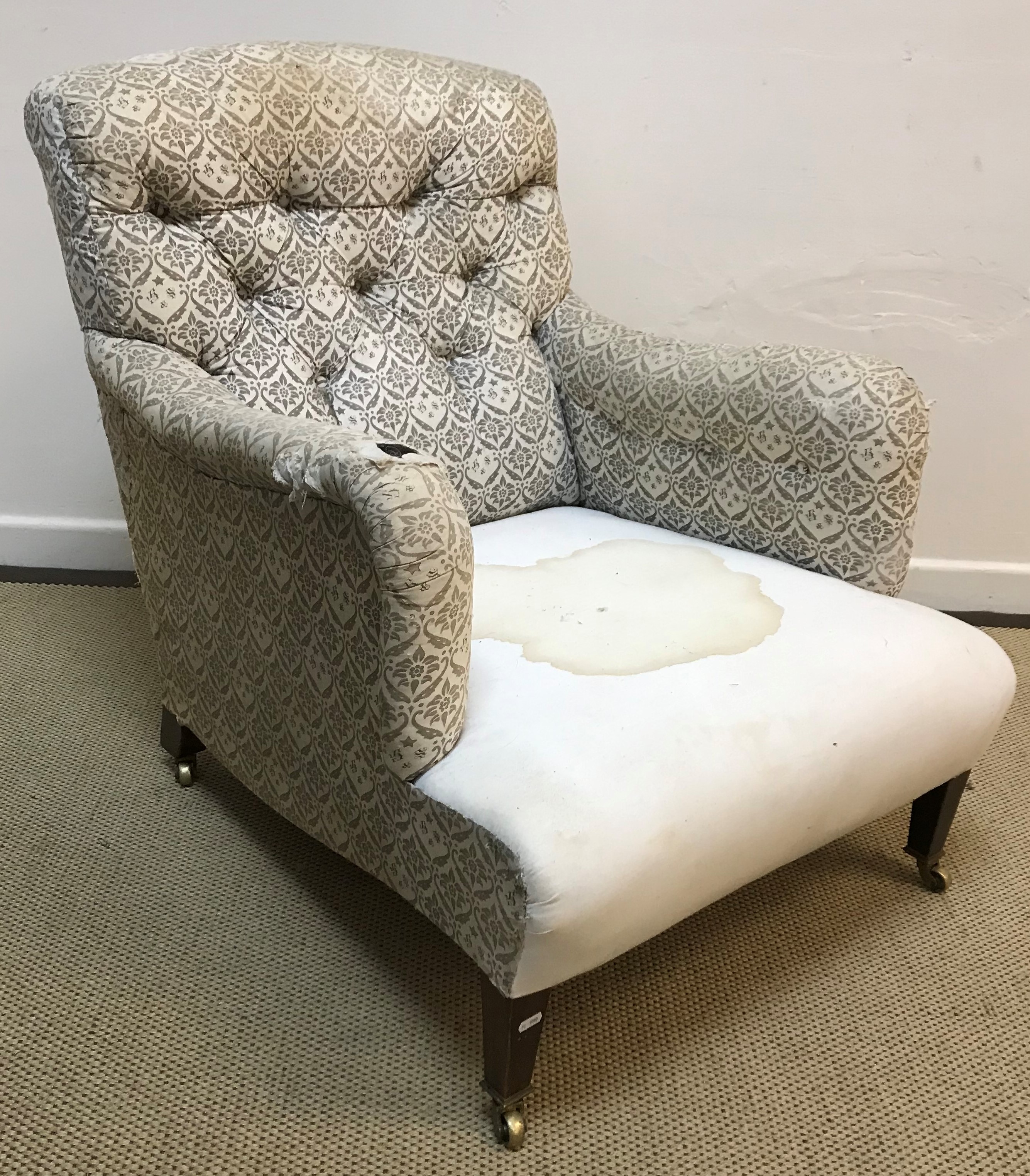 A circa 1900 upholstered armchair by Howard & Sons of London with original "H & S" ticking to the