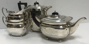 A George VI silver four piece tea set of rectangular bellied form raised on four bun feet with