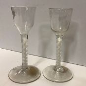 A pair of 18th Century glass wines with plain bowls on white enamel twist stems,