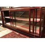 An early 20th Century mahogany framed and glazed shop display counter with rear sliding doors