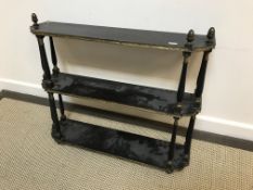 A 19th Century ebonised and gilt decorated three tier wall shelf, 66 cm wide x 16.5 cm deep x 57.