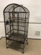 A vintage wrought iron parrot cage with wooden rails and bowl holders, 70.5 cm x 56.